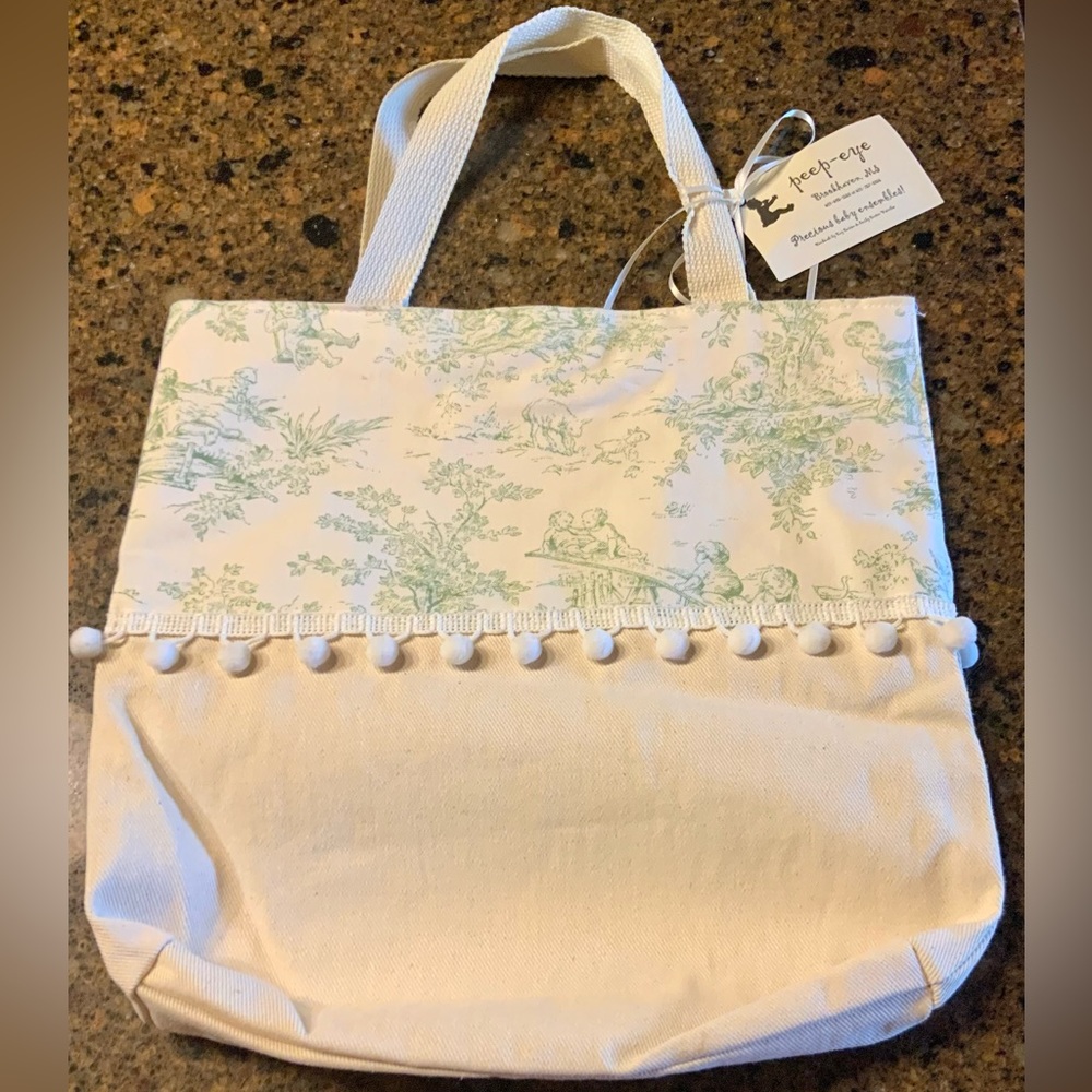 NWT as all tote canvas bag with lt green toile accent and Pom Pom trim. 15” x14”